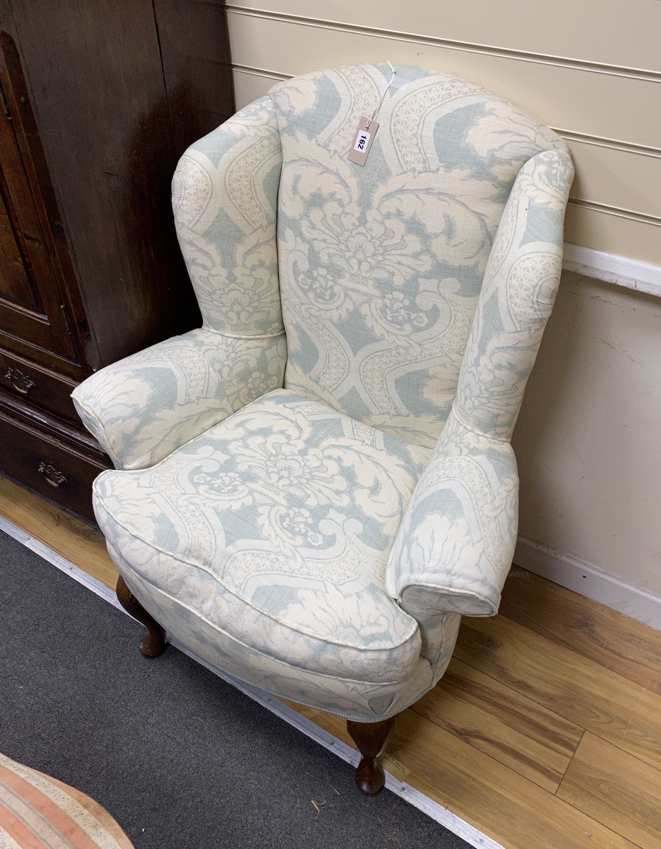 A pair of George I style upholstered walnut wing armchairs, width 84cm, depth 70cm, height 110cm